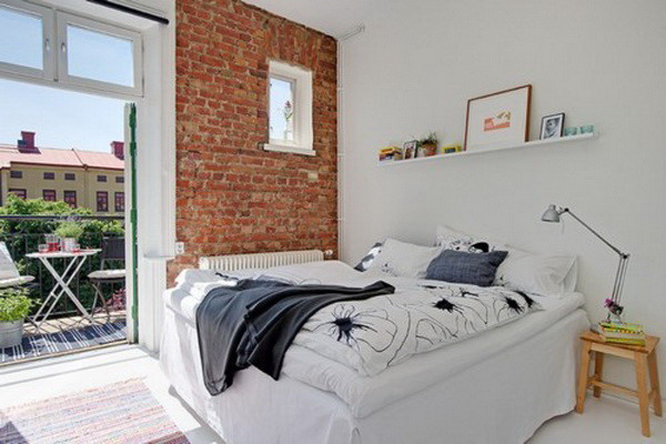 Pared de ladrillo a la vista en dormitorio pequeño