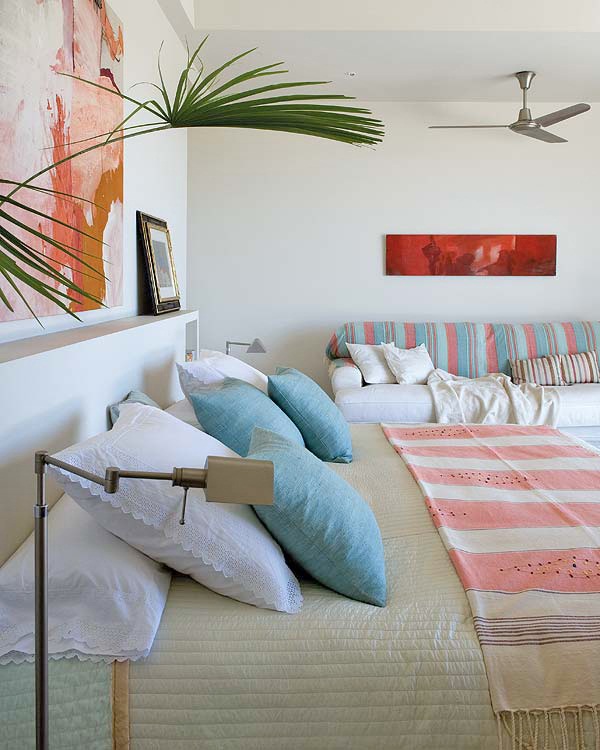 Paredes blancas y detalles de color con cuadros y textil