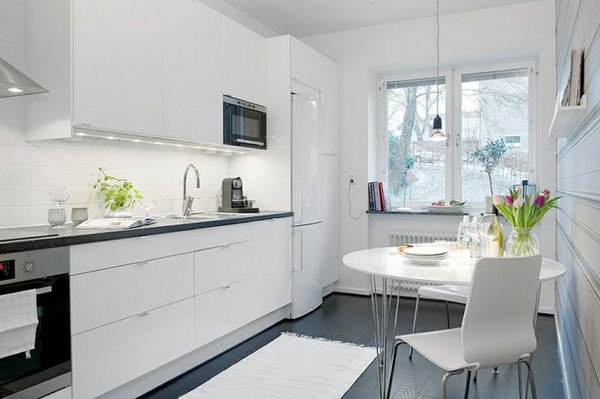 Muebles de cocina blancos, encimera y suelo negros