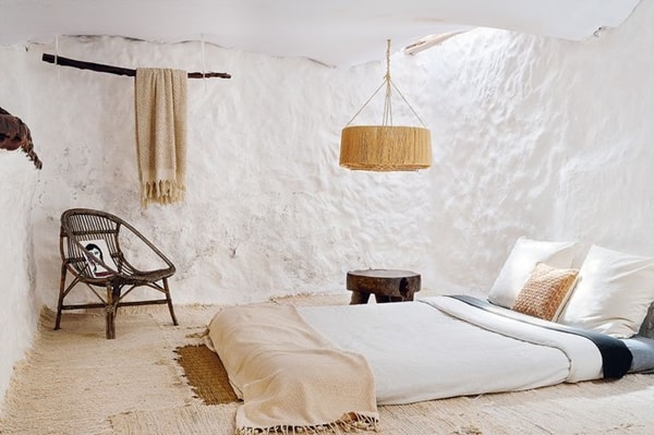 Dormitorio rústico con lámpara de mimbre
