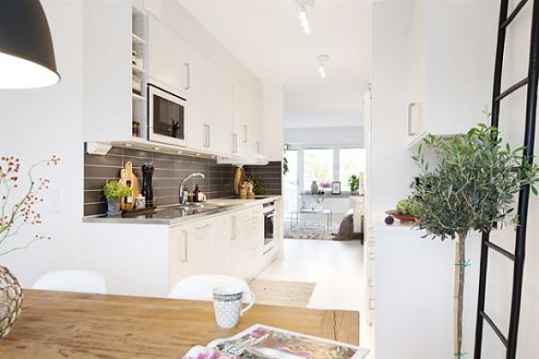 Cocina con muebles blancos y mesa de madera natural