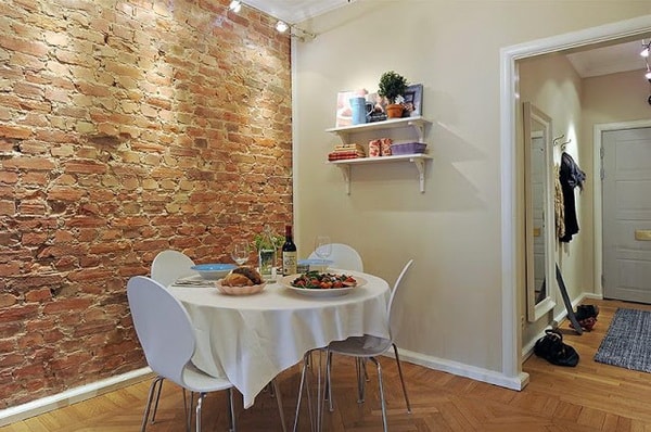 Comedor con pared de ladrillo a la vista