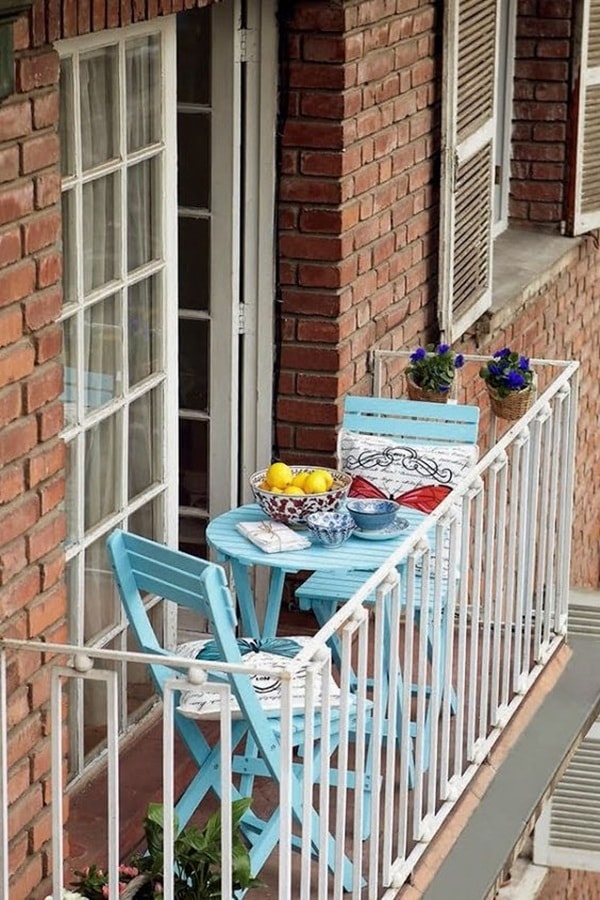 Mesa y sillas celestes en un diminuto balcón