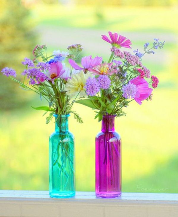 Botellas de cristal de colores como floreros