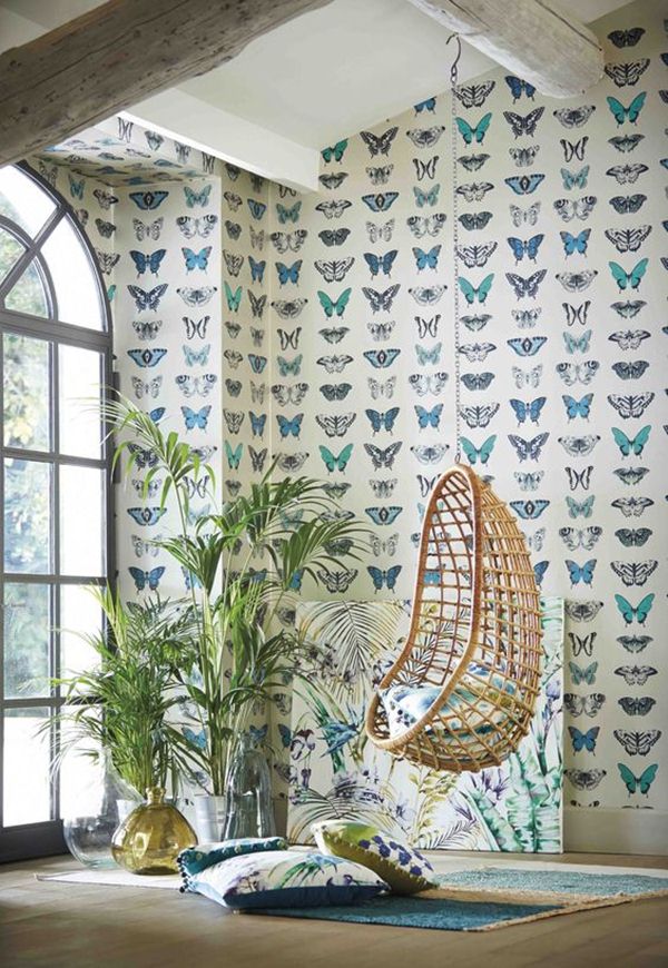 Silla colgante de mimbre y mariposas en las paredes