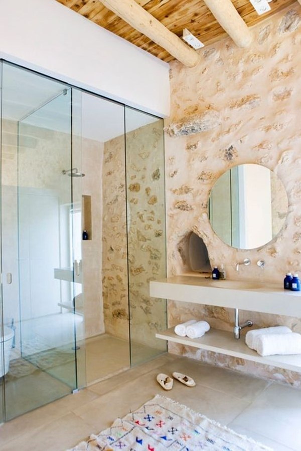 Baño con pared de piedra