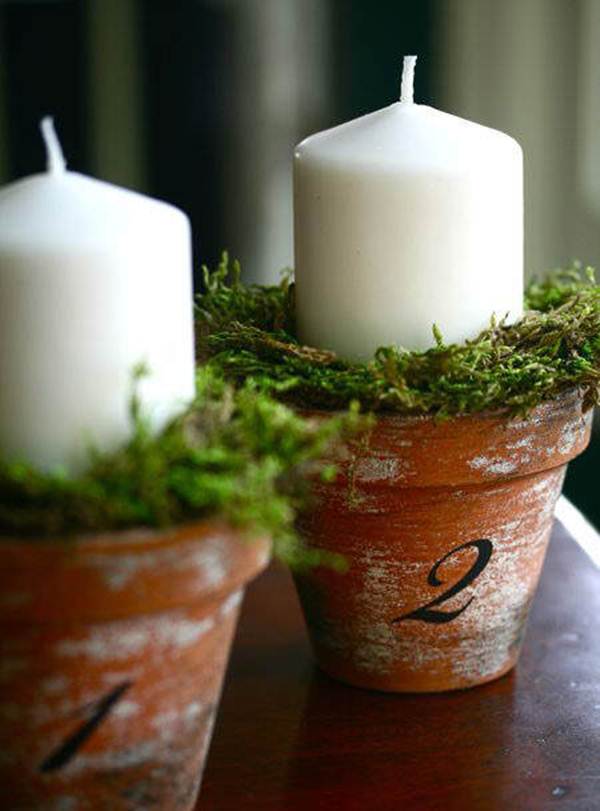 Centro de mesa navideño con pequeñas macetas y velas