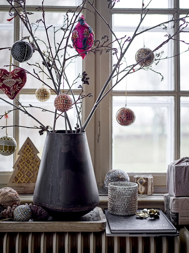 Jarrón con ramas y adornos de Navidad