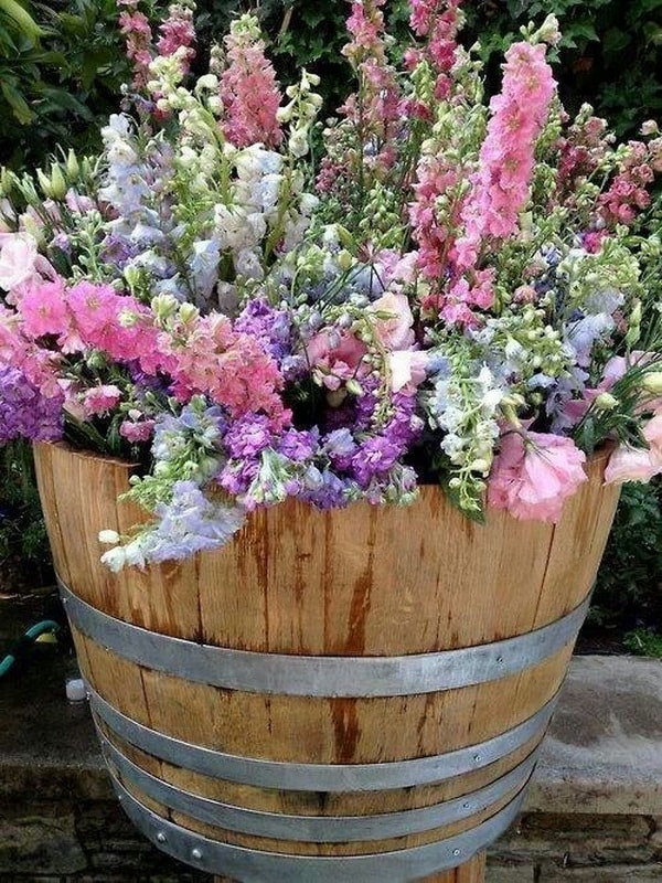 Barril de madera con flores para decorar el jardín