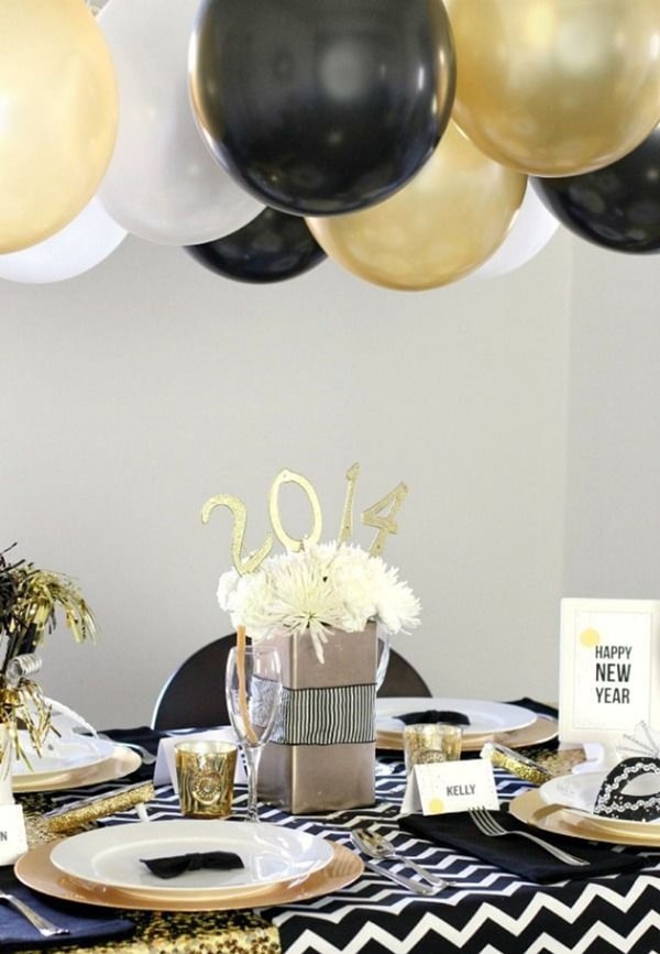 Decoración para la mesa de fin de año con globos en dorado, blanco y negro
