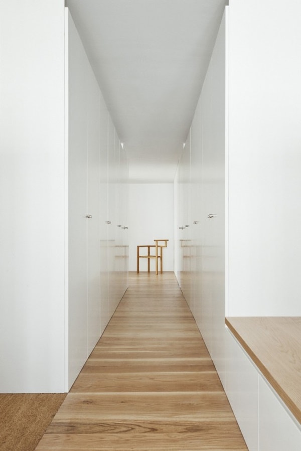 Pasillo blanco con suelo de madera