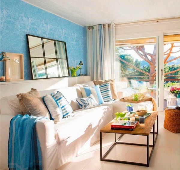 Muebles de madera y blancos con textiles y pared en tonos azules