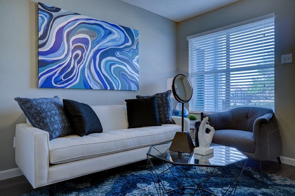 Salón con una gran alfombra y cuadro en tonos azules
