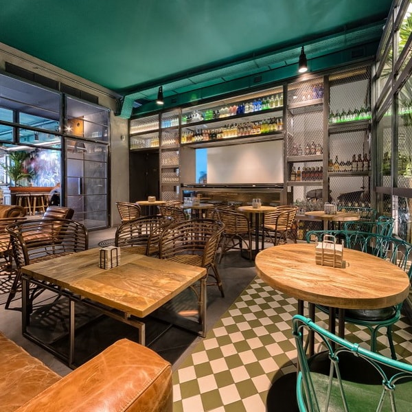 Locales comerciales decorados con mesas de madera y sillas de rattán