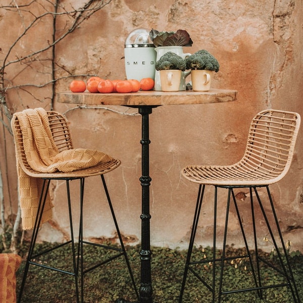 Mesa alta de madera y taburetes de rattán