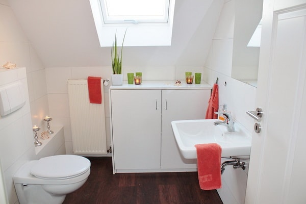 Baño blanco con suelo de madera
