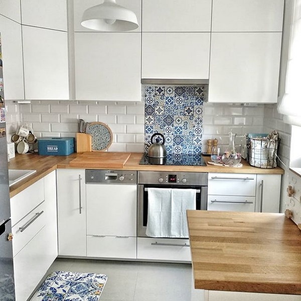 Pequeña cocina con encimera de madera y mosaico portugués