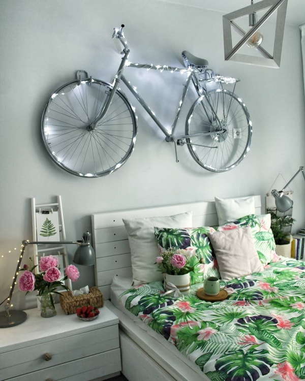 Bicicleta colgada en la pared del cabezal de la cama