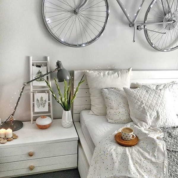 Dormitorio con cabecero de madera y bicicleta colgada de la pared
