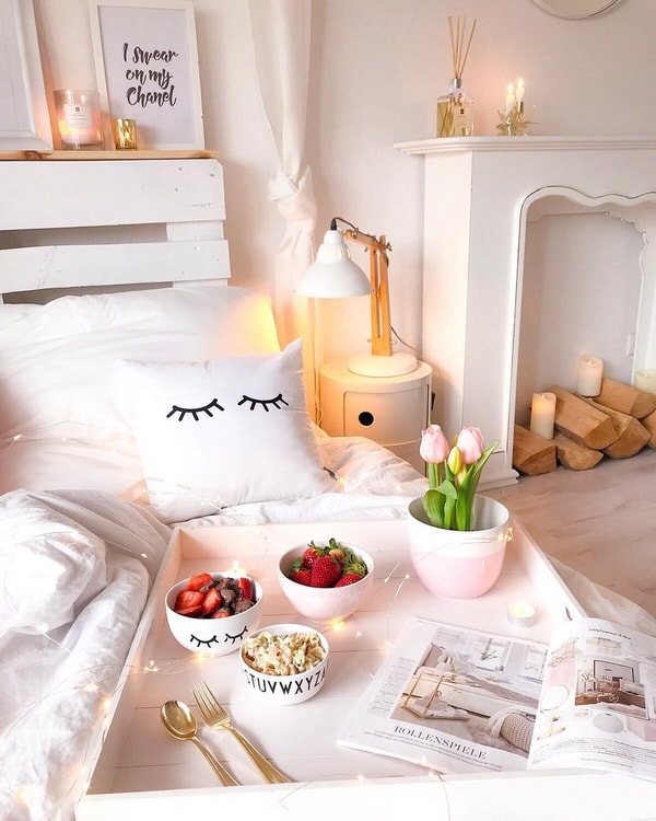 Cama hecha con palets en un pequeño apartamento femenino