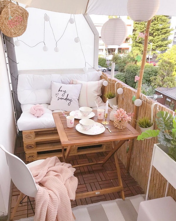 Pequeño balcón con sofá hecho con palets de madera