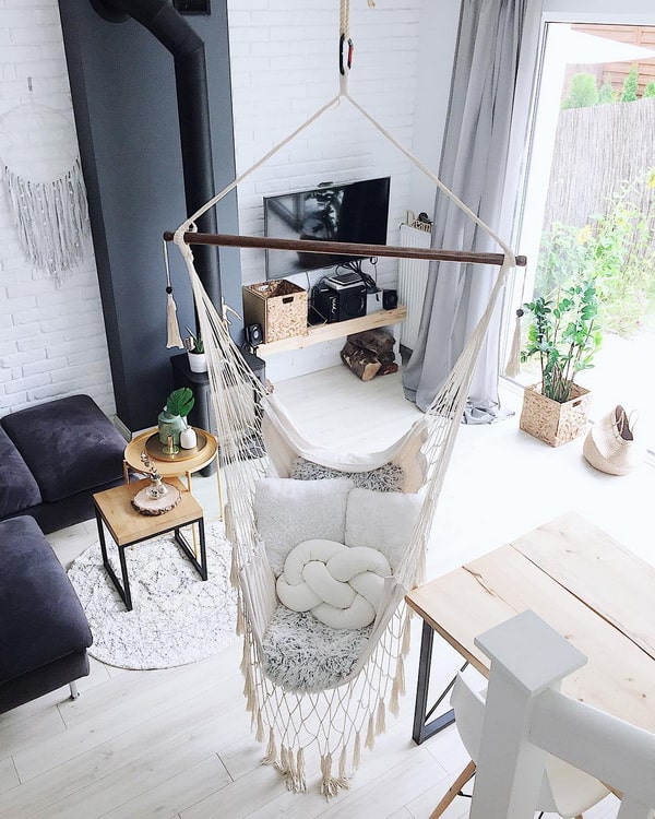 Silla colgante en medio de una sala con estilo escandinavo