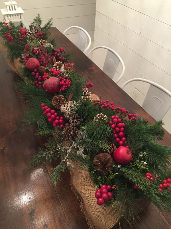 Centro de mesa navideño con caja de madera, piñas y ramas