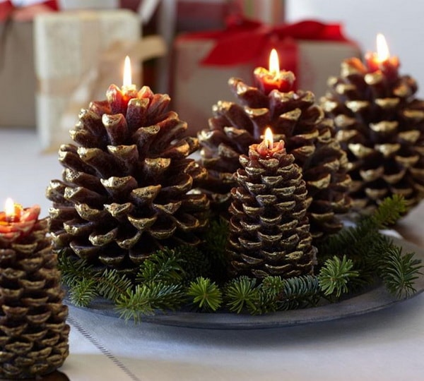 centro de mesa navideño con piñas y velas
