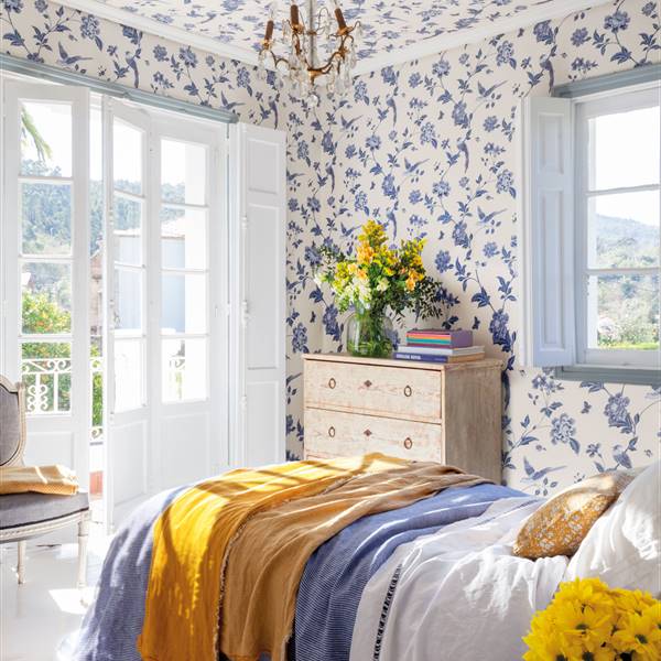 Papel pintado en azul y ropa de cama en amarillo