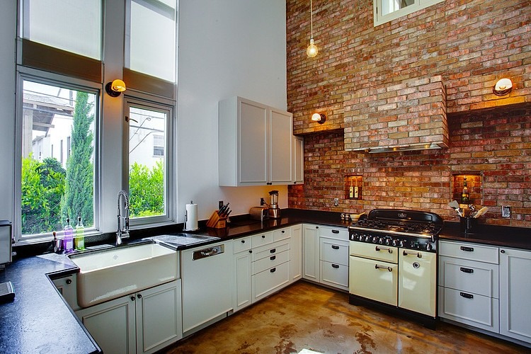 Cocina estilo industrial con pared de ladrillo visto