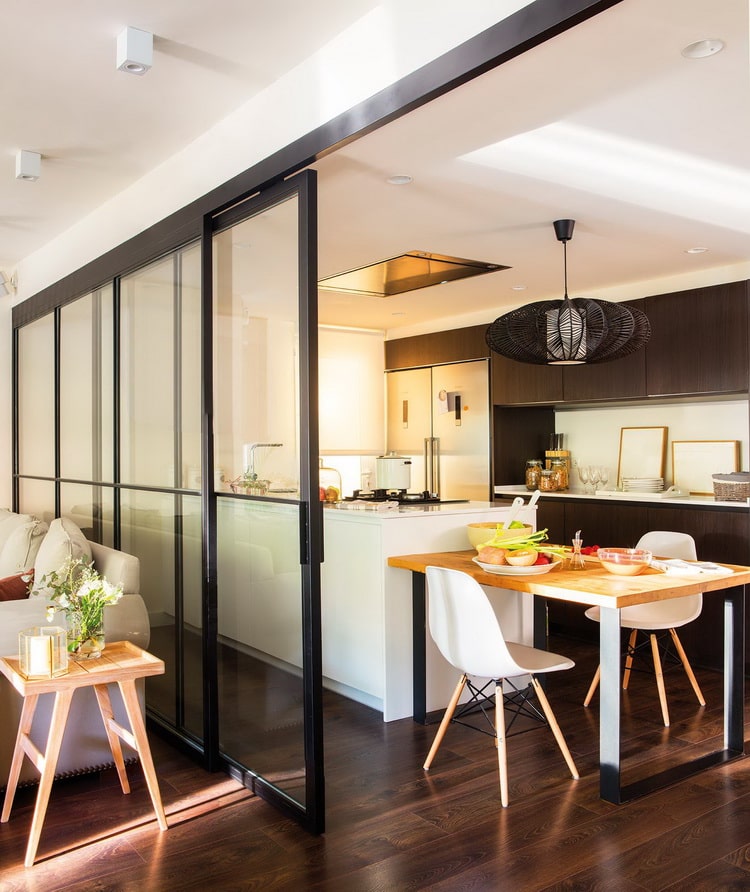 Cocina abierta al salón con suelo de madera oscura