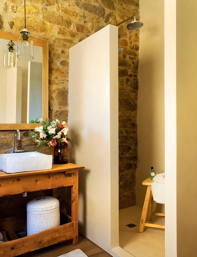Baños rústicos con paredes de piedra