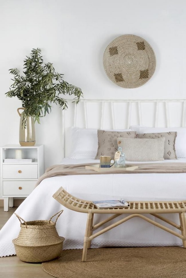 Decorar el pie de cama con un baúl de mimbre