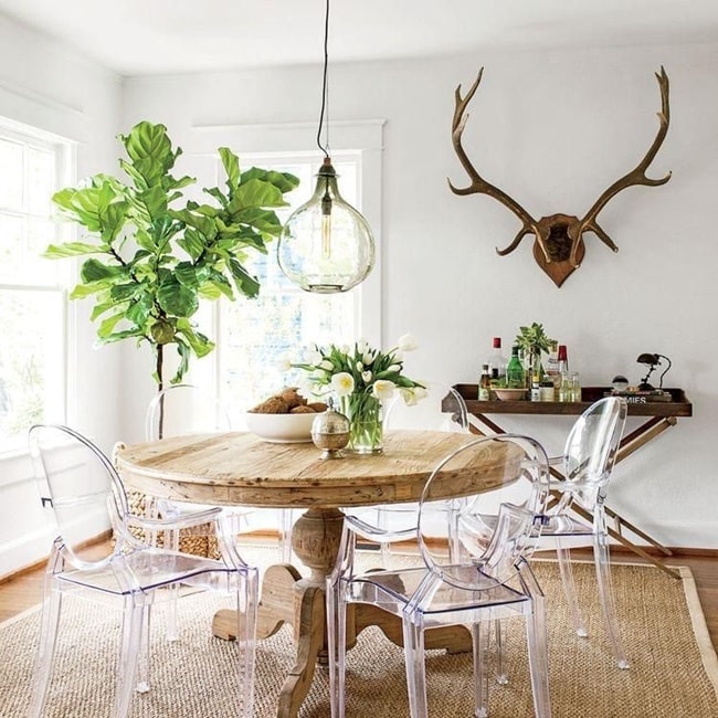 Sillas traslúcidas y mesa rústica de madera