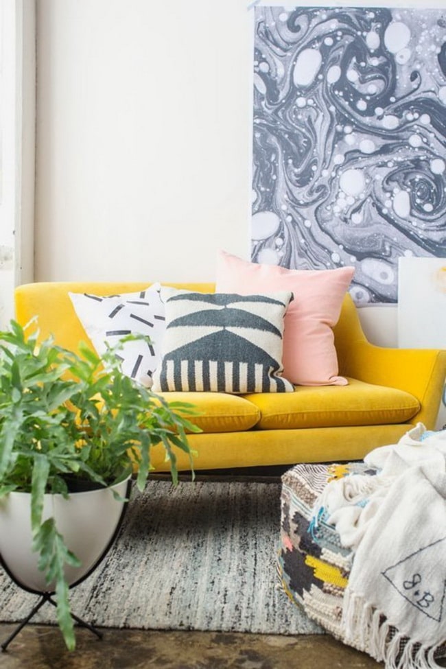 Salón con plantas y sofá amarillo
