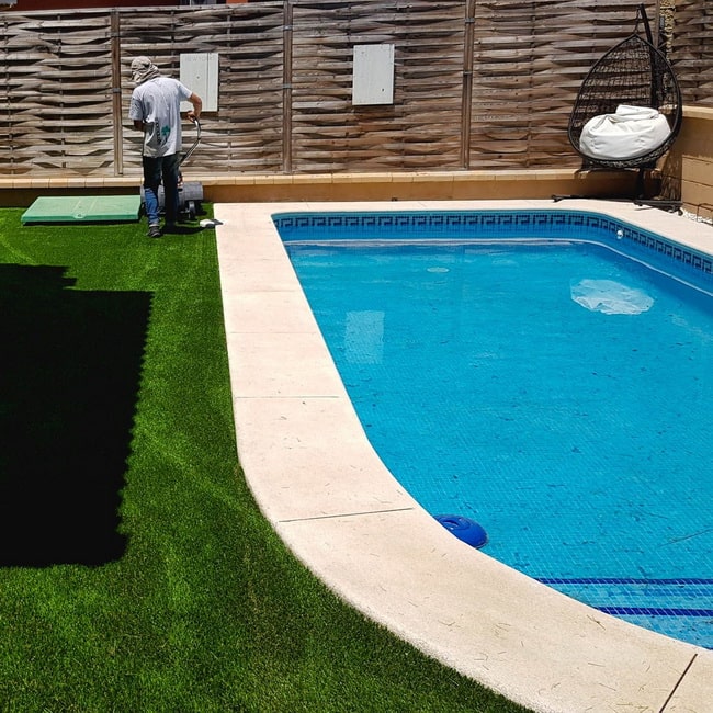 Jardín con piscina y césped artificial