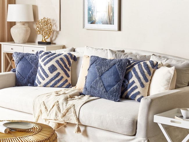 Cojines azules para decorar un sofá beige
