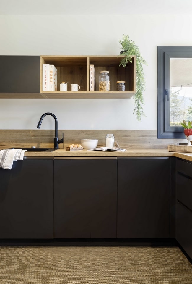 Muebles de cocina negros y encimera de madera