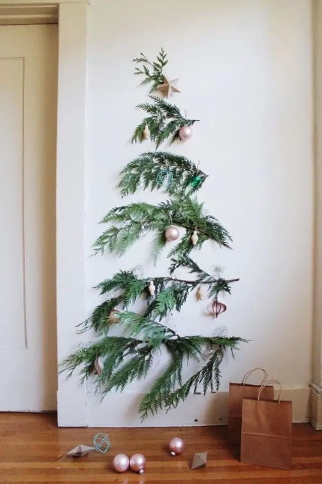 Árbol navideño de pared hecho con ramas verdes