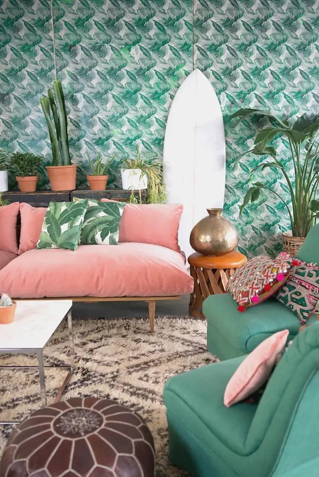 Salón con pared verde y sofá coral