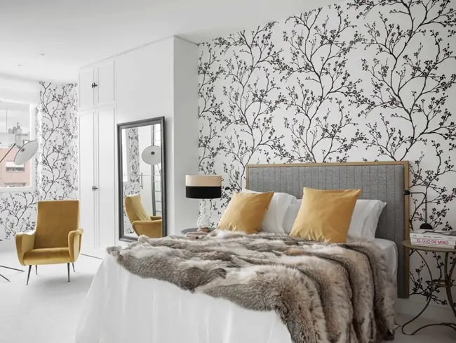 Dormitorio de matrimonio con papel pintado en la pared del cabecero