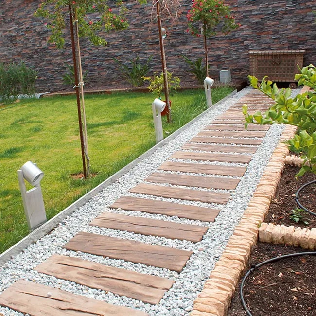 Camino de jardín con madera y piedra Camino de jardín con madera y piedra