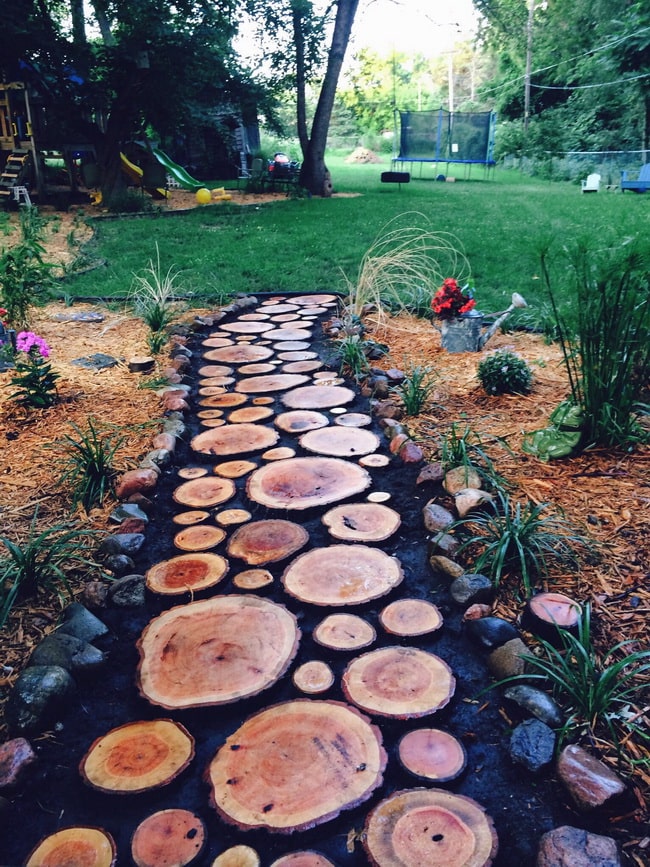 Camino de jardín con piedras y troncos Camino de jardín con piedras y troncos