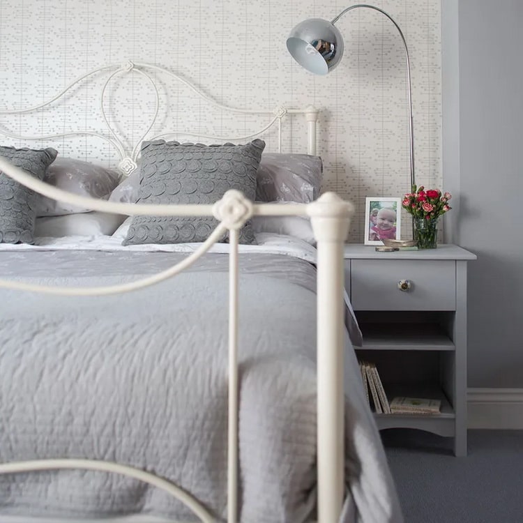 Dormitorio gris con cama de forja