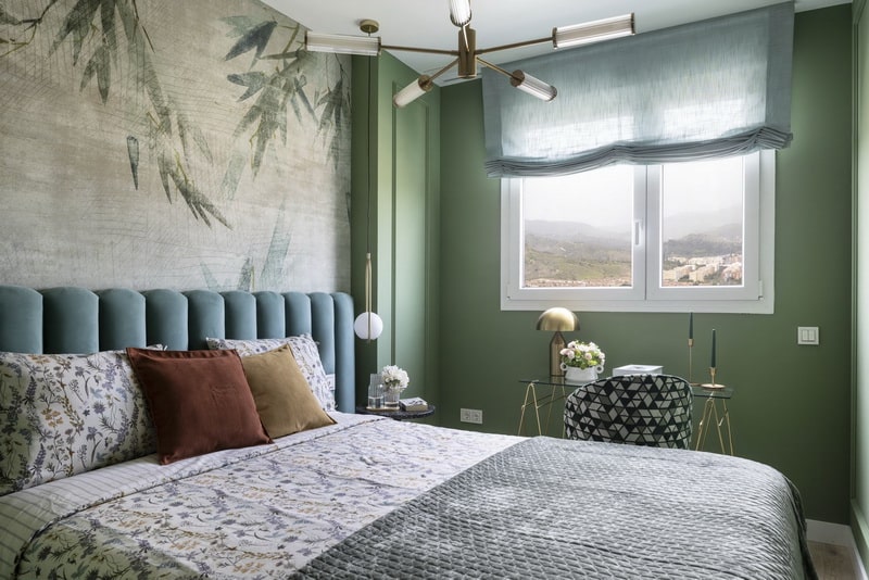 Dormitorio principal con cabecero tapizado y mural decorativo.