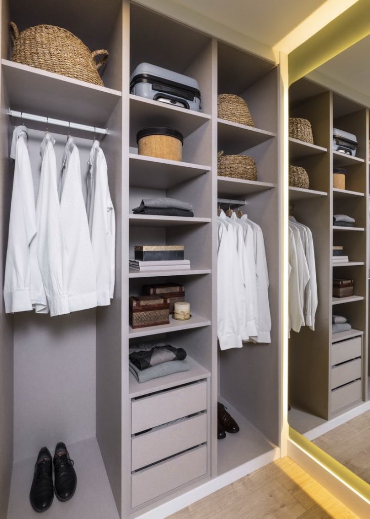 Vestidor moderno con mobiliario a medida y espejo decorativo.