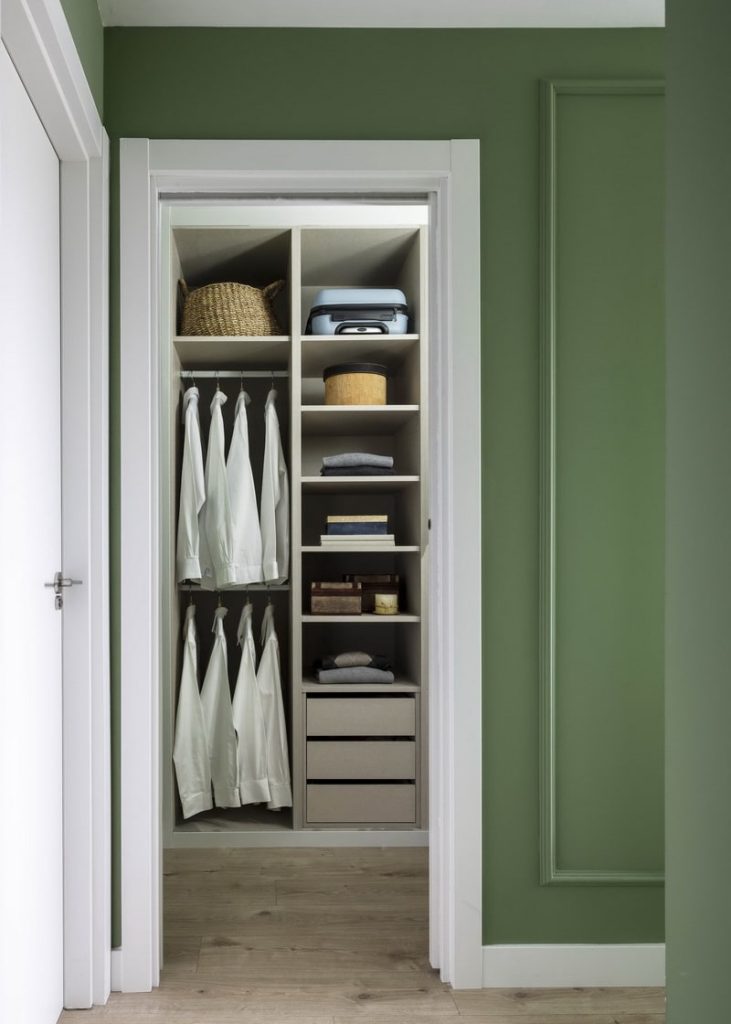 Espacio de vestidor con armarios organizados y cestas de fibras naturales.