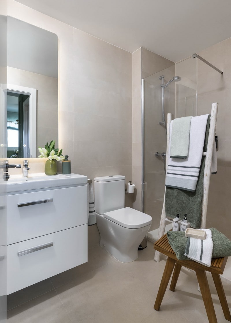 Baño en porcelánico beige con mueble suspendido y diseño minimalista.