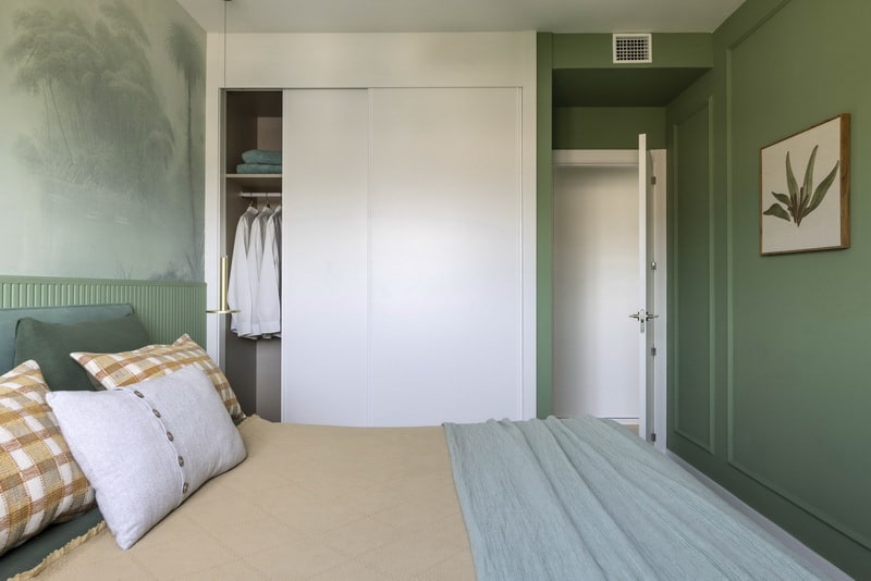 Dormitorio con cabecero de palillería en tono verde.