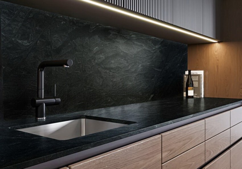 Cocina moderna con encimera negra y muebles color madera